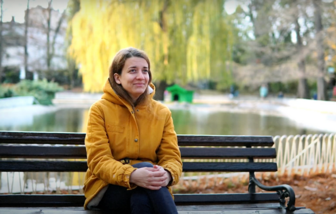 Maja, a graduate student at the Academy of Arts in Novi Sad, Serbia, sitting on a bench in a park.
