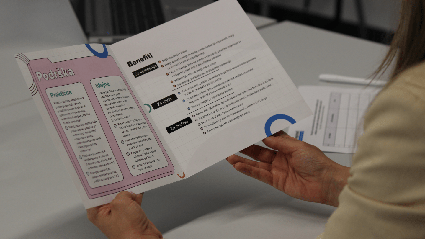 Osoba drži pamflet za „Proširenje izbora“ i čita informacije o politikama prilagođenim porodicama.